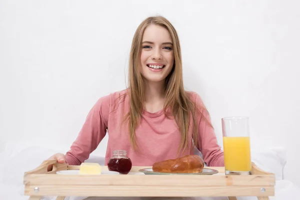Lycklig kvinna med frukost på träbricka — Stockfoto