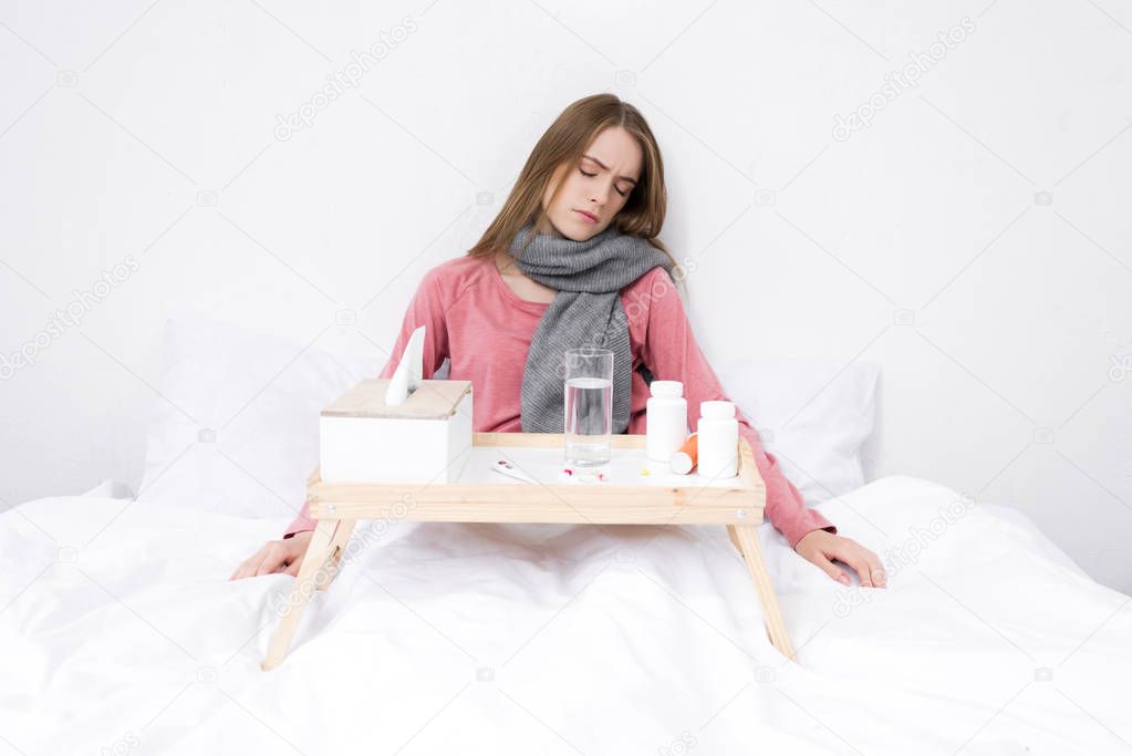 sick woman with medicines on tray