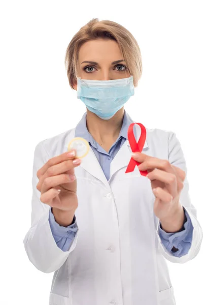 Doctor with aids ribbon and condom — Free Stock Photo