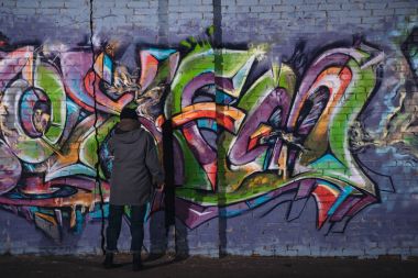arkadan görünüşü sokak sanatçı boyama renkli grafiti duvara geceleri 