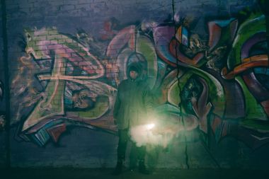 duman bombası basılı tutup duvara graffiti ile geceleri ayakta adam