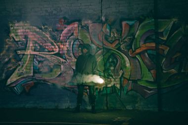 duman bombası basılı tutup duvara graffiti ile geceleri ayakta kişi