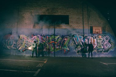 sis bombası basılı tutup duvara graffiti ile geceleri ayakta insanlar