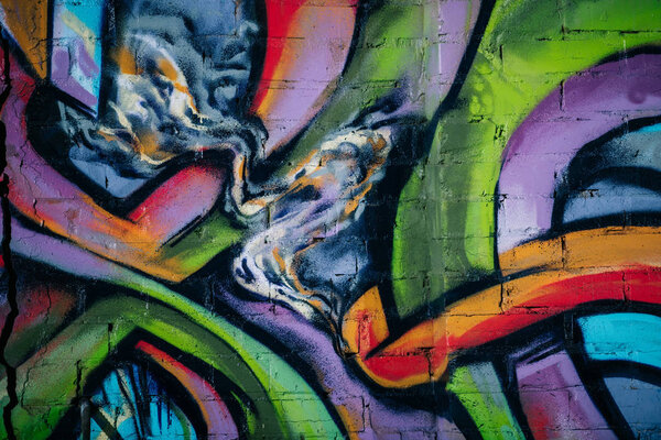 close up of colorful graffiti on wall in city, street art 