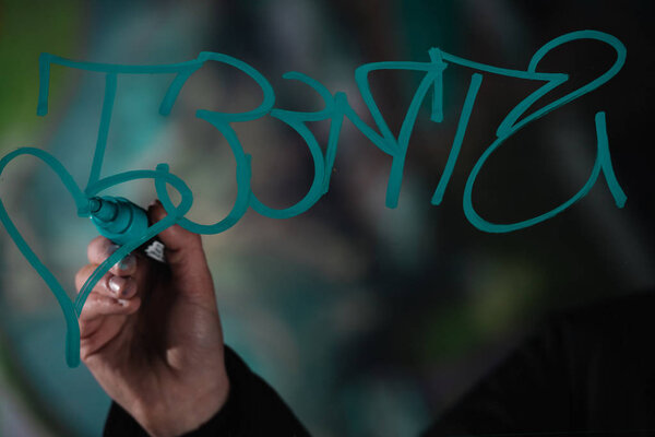 cropped view of man writing graffiti with marker