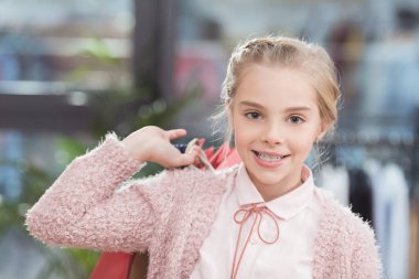 Kameraya bakarak ve kağıt poşet elinde tutan mutlu çocuk  