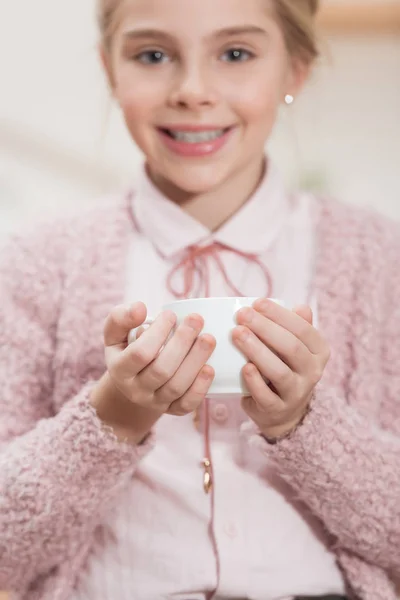 Smiling Kid Holding Tea Cup Hands Looking Camera — Free Stock Photo