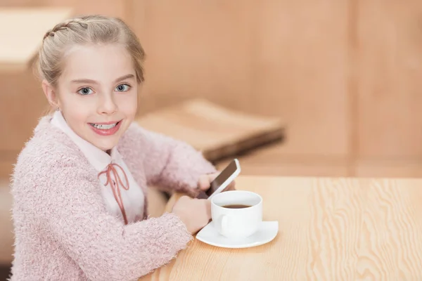 Enfant Souriant Assis Table Avec Smartphone Dans Les Mains — Photo