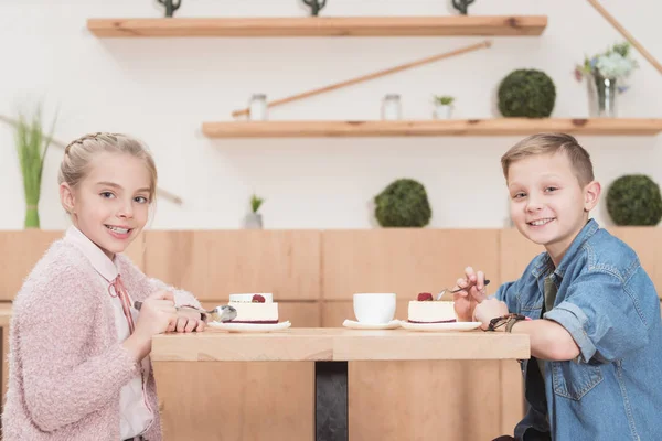 Crianças Sentadas Mesa Café Enquanto Olha Para Câmera Outro Sorrindo — Fotografia de Stock