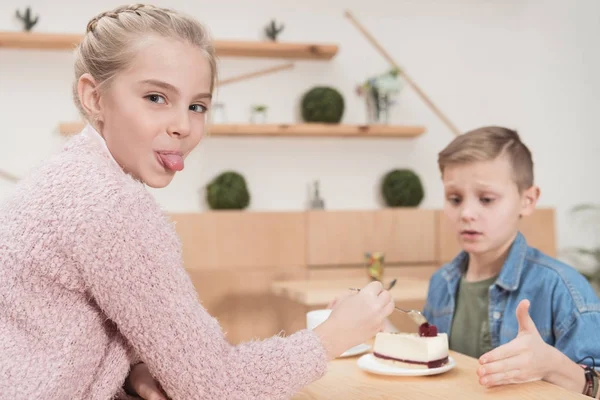 Kid Visar Tungan Till Kameran När Sitter Vid Bordet Mot — Stockfoto