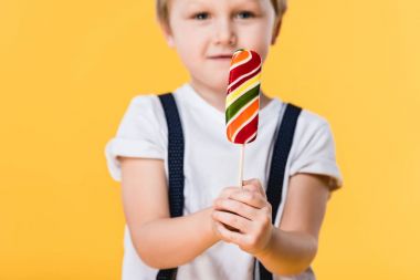 sevimli küçük çocuk lolipop sarı izole el ile seçici odak