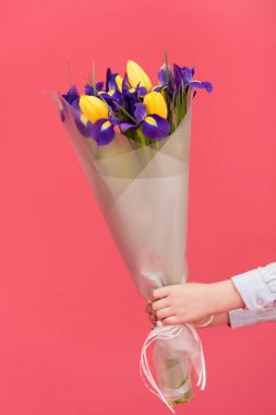 bir buket çiçek pembe üzerinde izole tutan çocuk kısmi görünümü