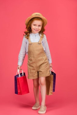 alışveriş torbaları pink izole ile casual giyim gülümseyen çocuk