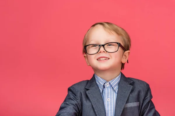 ピンクに分離された眼鏡で笑みを浮かべて少年の肖像画 — ストック写真
