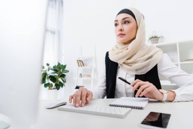 portrait of focused arabic businesswoman working on computer in office clipart