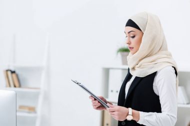yan görünüm alanındaki klasörle hijab içinde Müslüman işkadını ofiste eller