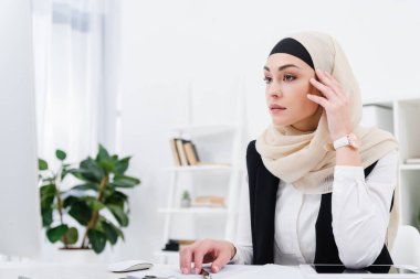 Ofiste oturan düşünceli Arap iş kadını