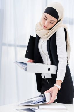 hijab smartphone Office konuşurken belgelerle işkadını portresi