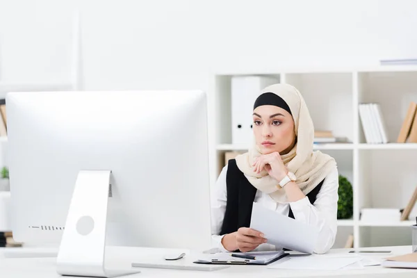 Portrait Thoughtful Muslim Businesswoman Hijab Papers Looking Computer Screen Workplace — Stock Photo, Image