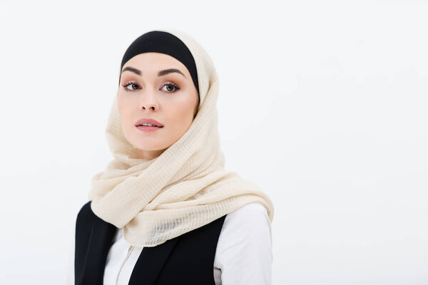 portrait of muslim businesswoman in hijab looking away isolated on grey
