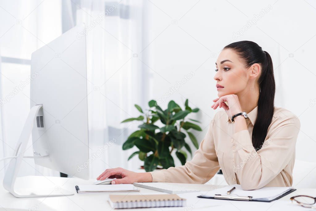 side view of concentrated businesswoman working on computer in office