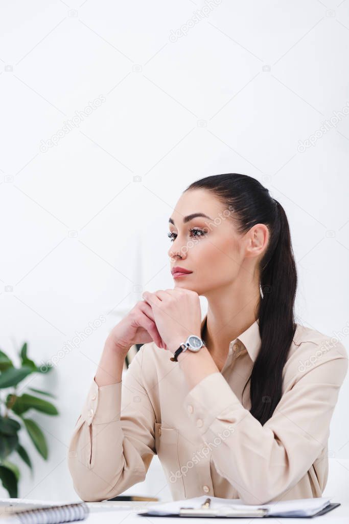 portrait of pensive businesswoman looking away at workplace