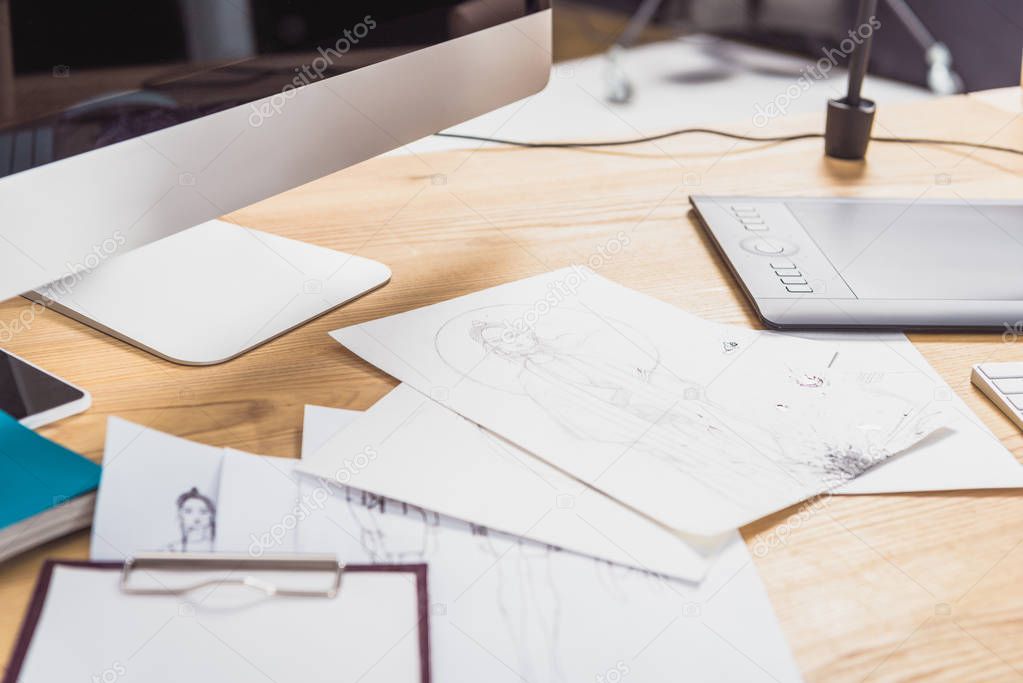 Work table of designer with sketches and computer