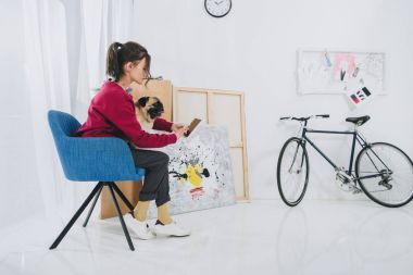 Güzel Bayan Tablet ve sarılma pug köpek evde kullanma