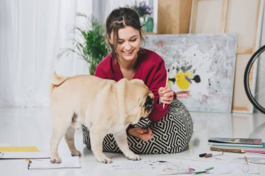 Güzel Bayan Pug yavrusu ile katta oynama