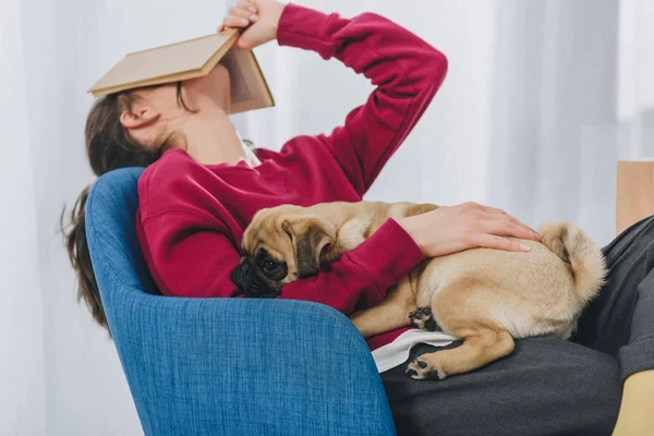Pretty Lady Hugging Pug Covering Her Face Book — Stock Photo, Image