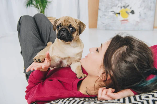 パグの子犬と遊ぶ若い女性 — ストック写真