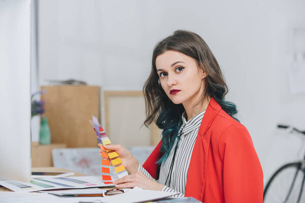 Привлекательная молодая девушка, работающая с палитрой за рабочим столом с компьютером
