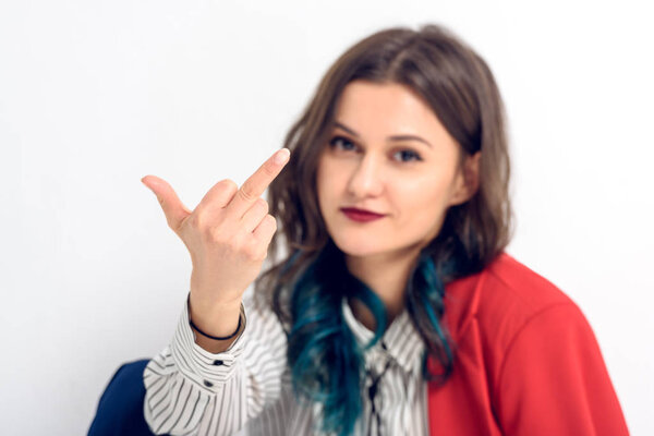 Young woman showing middle finger on white background