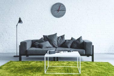 Divan tarafından masada dijital becerikli alet ile modern oda 