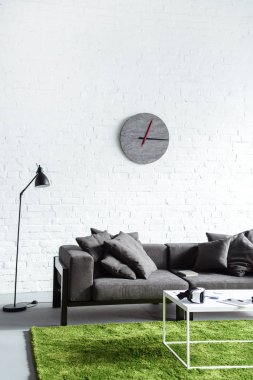 Digital gadgets in cozy interior with modern grey sofa clipart