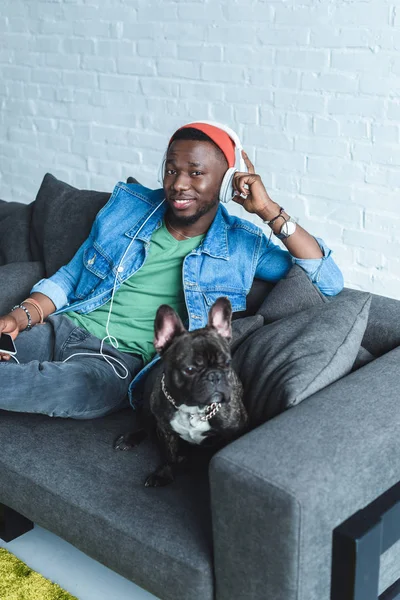 Französischer Hund Auf Dem Sofa Sitzt Neben Einem Afroamerikaner Mit — kostenloses Stockfoto