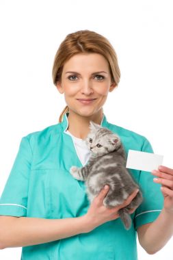 Veteriner holding yavru kedi ve boş kartı üzerinde beyaz izole gülümseyen