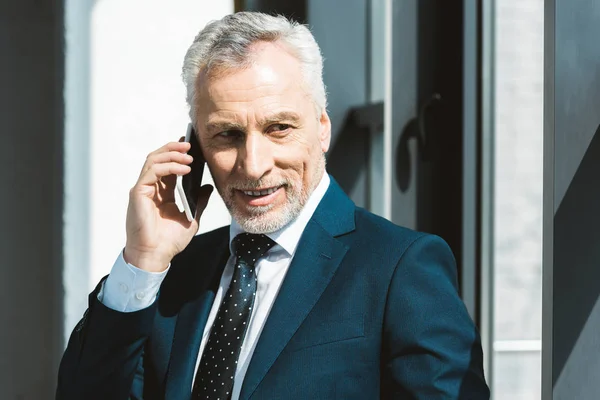 Sonriente Hombre Negocios Senior Hablando Por Teléfono Inteligente Mirando Hacia — Foto de stock gratis