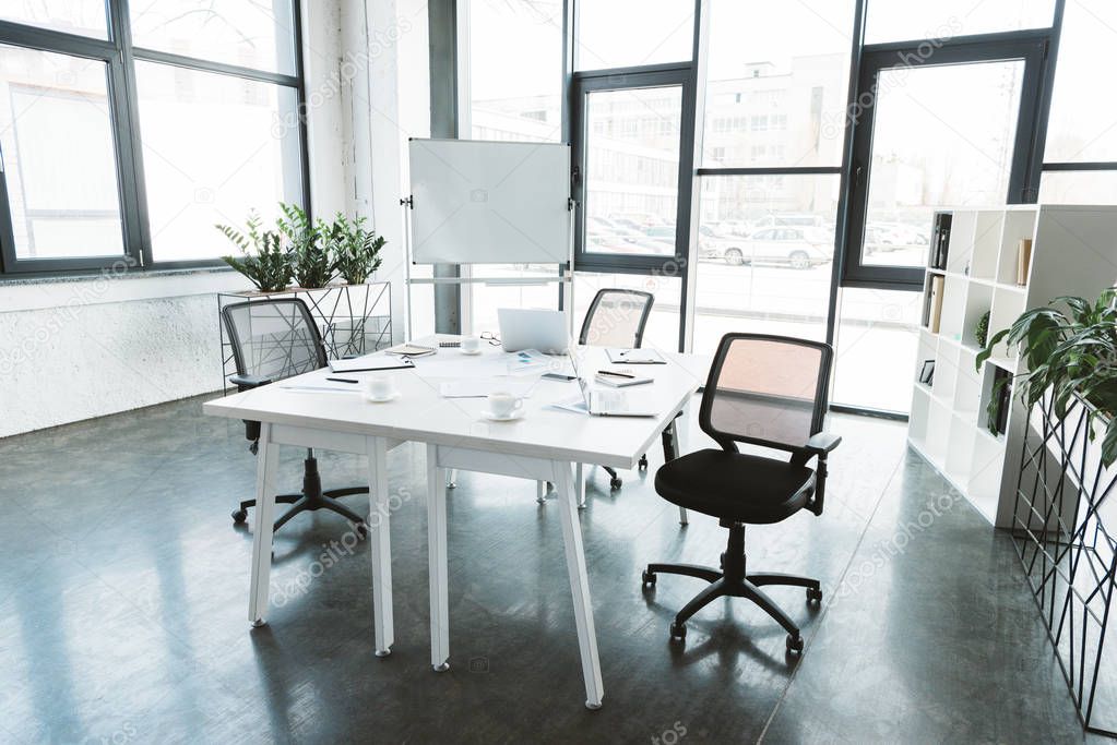 modern office interior with desk, papers, chairs and whiteboard