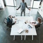 Vista de ángulo alto de colegas profesionales de negocios multiétnicos teniendo conversación durante la reunión de negocios