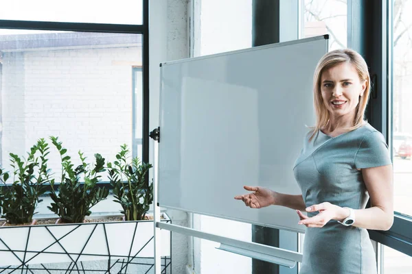 Attraktive Geschäftsfrau Steht Neben Leerem Whiteboard Und Lächelt Die Kamera — Stockfoto