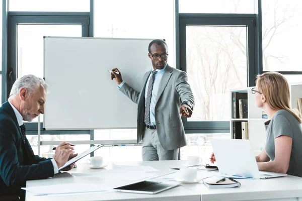 Young African American Businessman Writing Whiteboard Looking Colleagues Business Meeting — Stock Photo, Image