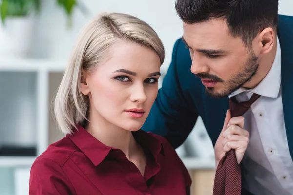 Joven Mujer Negocios Mirando Cámara Mientras Sostiene Corbata Guapo Hombre — Foto de Stock