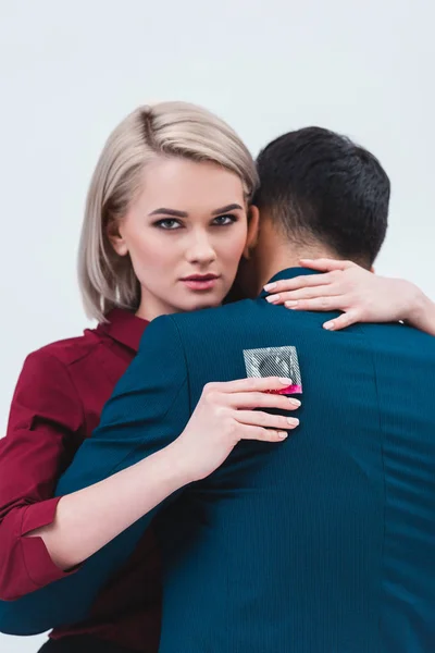 Buisnesswoman Sosteniendo Condón Mirando Cámara Mientras Abraza Con Colega Masculino — Foto de Stock