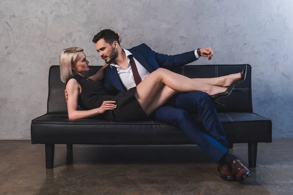 诱人的年轻夫妇拥抱和看对方在前戏沙发上 — 图库照片