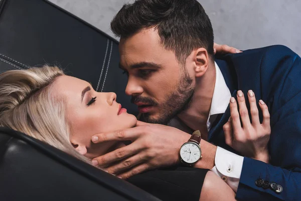 オフィスのソファでキスをすることができるセクシーな若いカップルのクローズ アップ ビュー — ストック写真