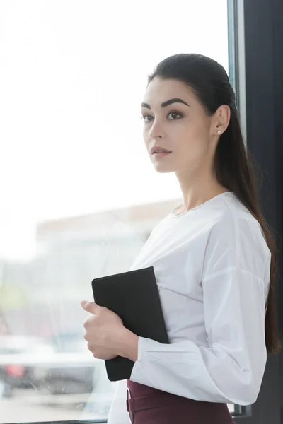 Beautiful Pensive Young Businesswoman Holding Notebook Looking Away — Free Stock Photo