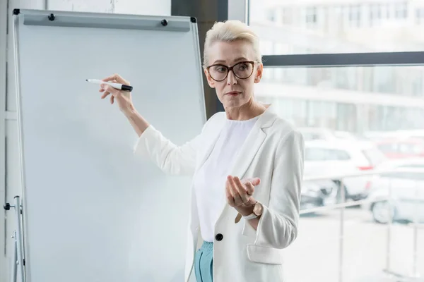 Serious Senior Businesswoman Eyeglasses Writing Whiteboard Making Presentation Office — Stock Photo, Image