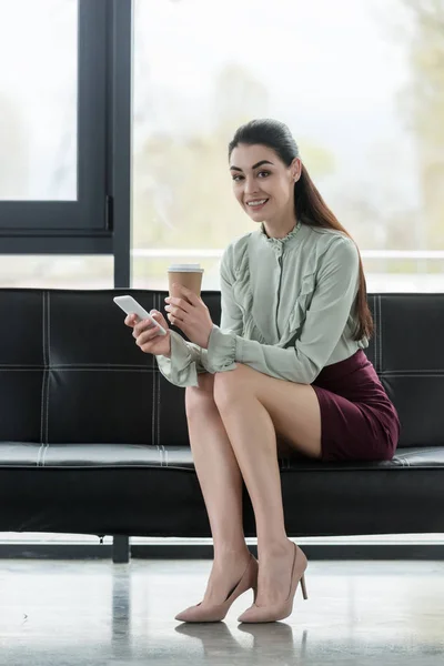 Atrakcyjna Kobieta Interesu Trzymając Smartfon Kawę Iść Biurze — Darmowe zdjęcie stockowe