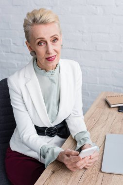 zarif üst düzey iş kadını smartphone kullanarak beyaz şık takım